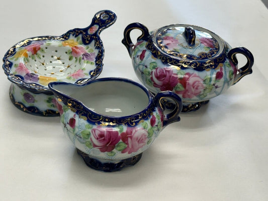 Hand-painted Japanese porcelain sugar, creamer, and strainer set.