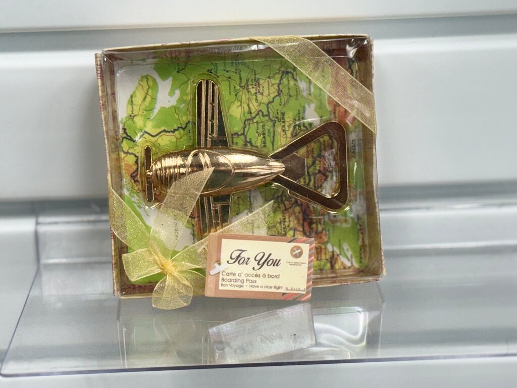 Gold-colored airplane bottle opener in package with Map Background